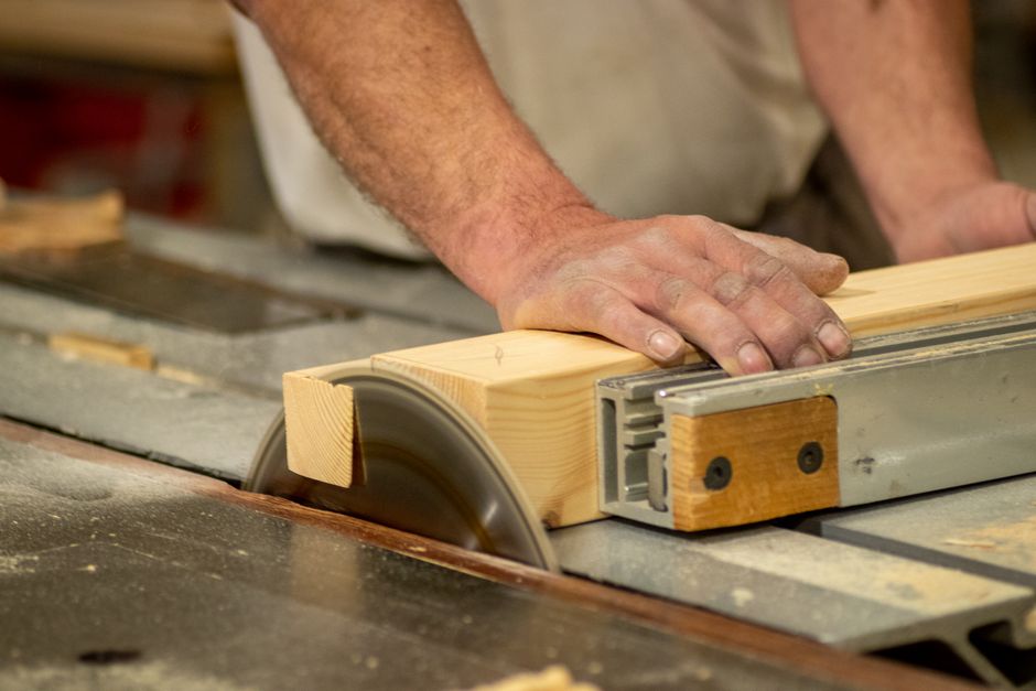 Carpenter meticulously crafting wood cabinets in a workshop
